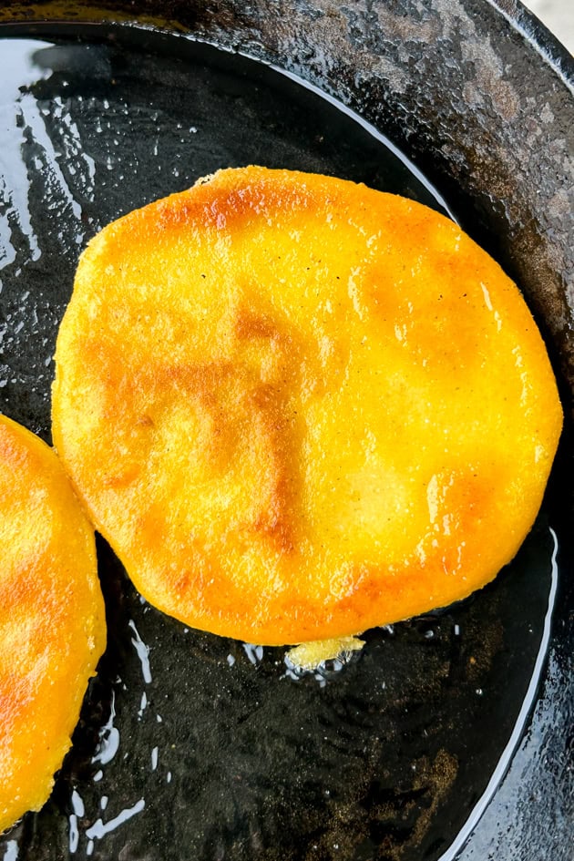 fresh arepas frying in oil