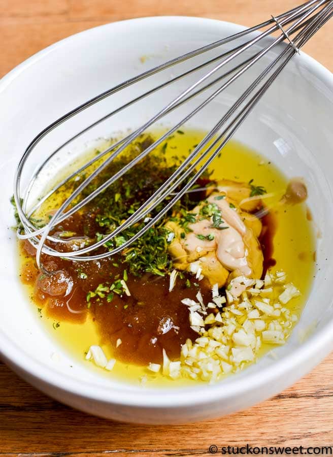 steak marinade ingredients in a white bowl with a whisk