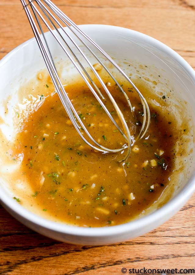 brown steak marinade in a white bowl with a whisk