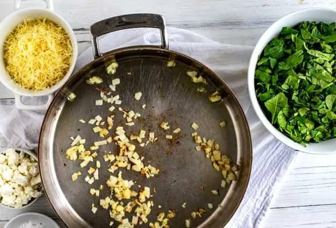 Image depicting onions cooking in a skillet.