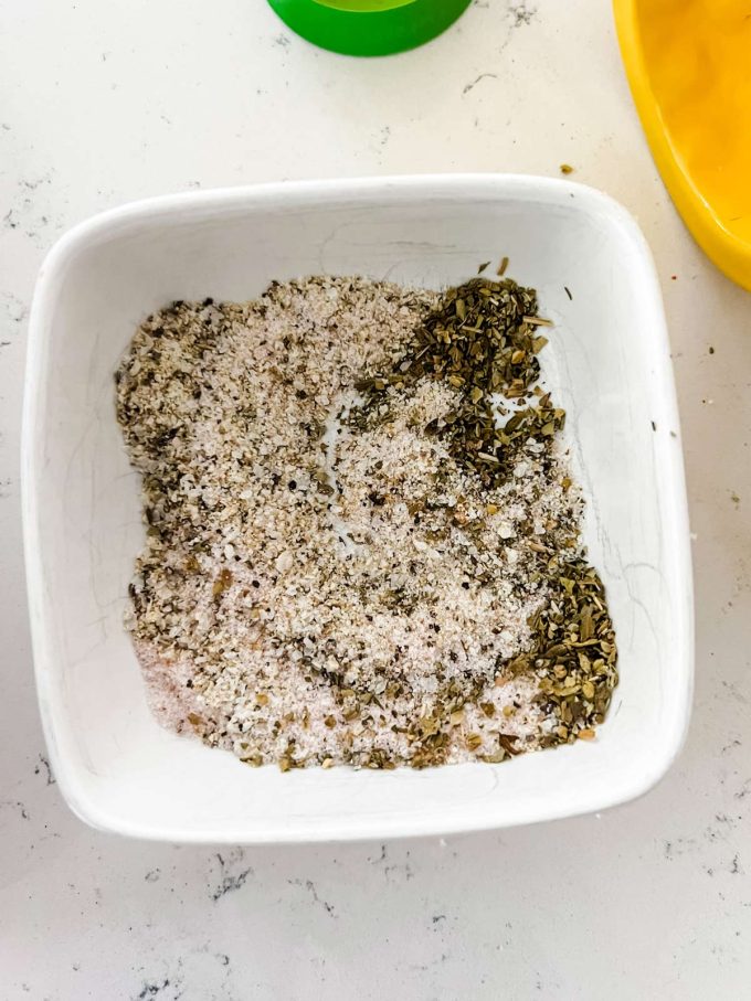 Lemon pepper seasoning and salt arranged in a small dish.