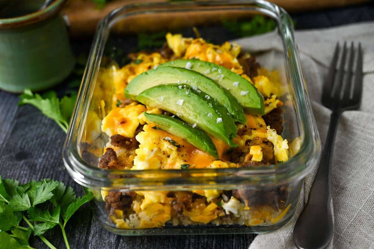 Side view of a breakfast bowl with fresh herbs adjacent.