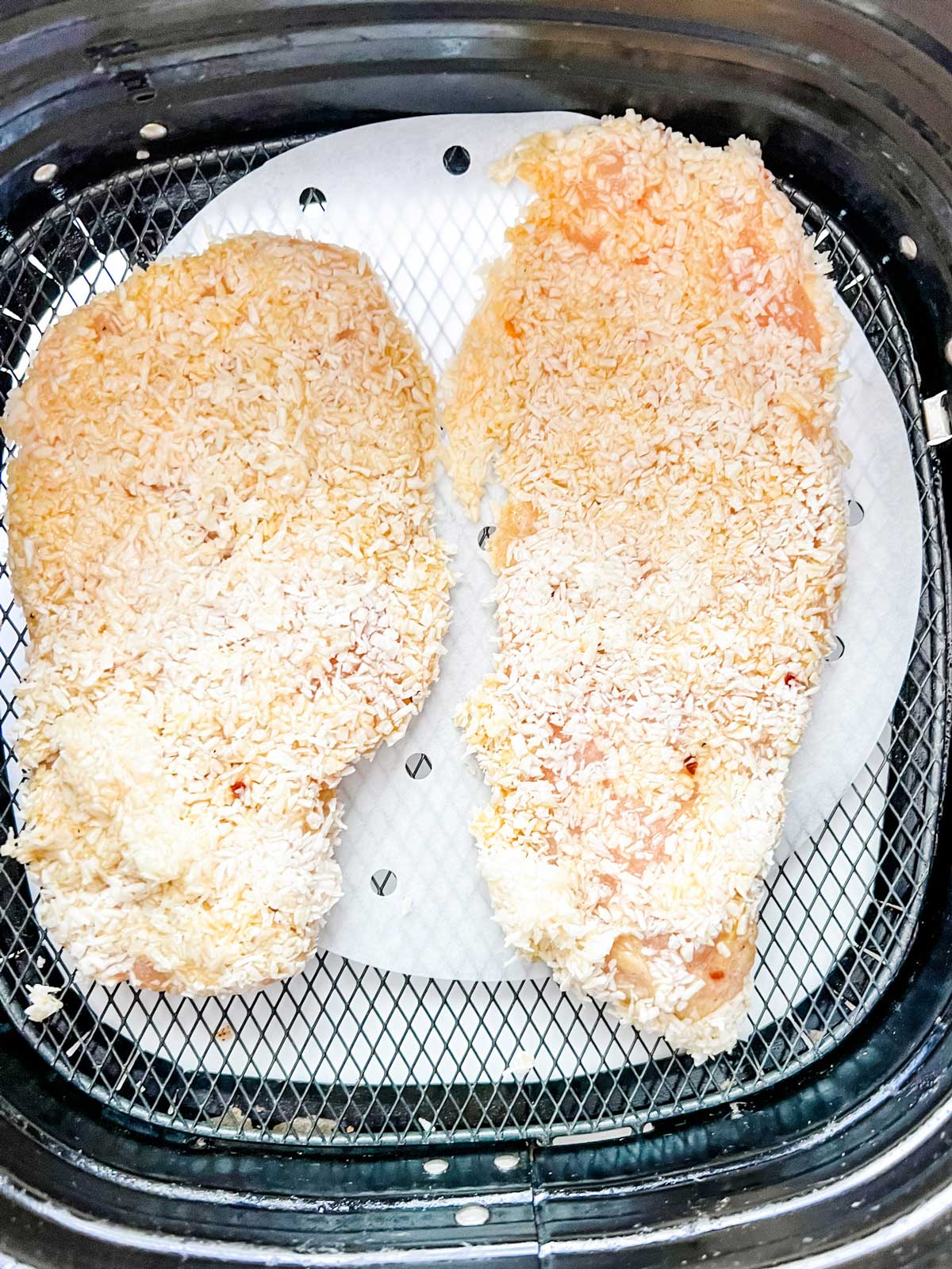 Keto coconut chicken in an air fryer basket.