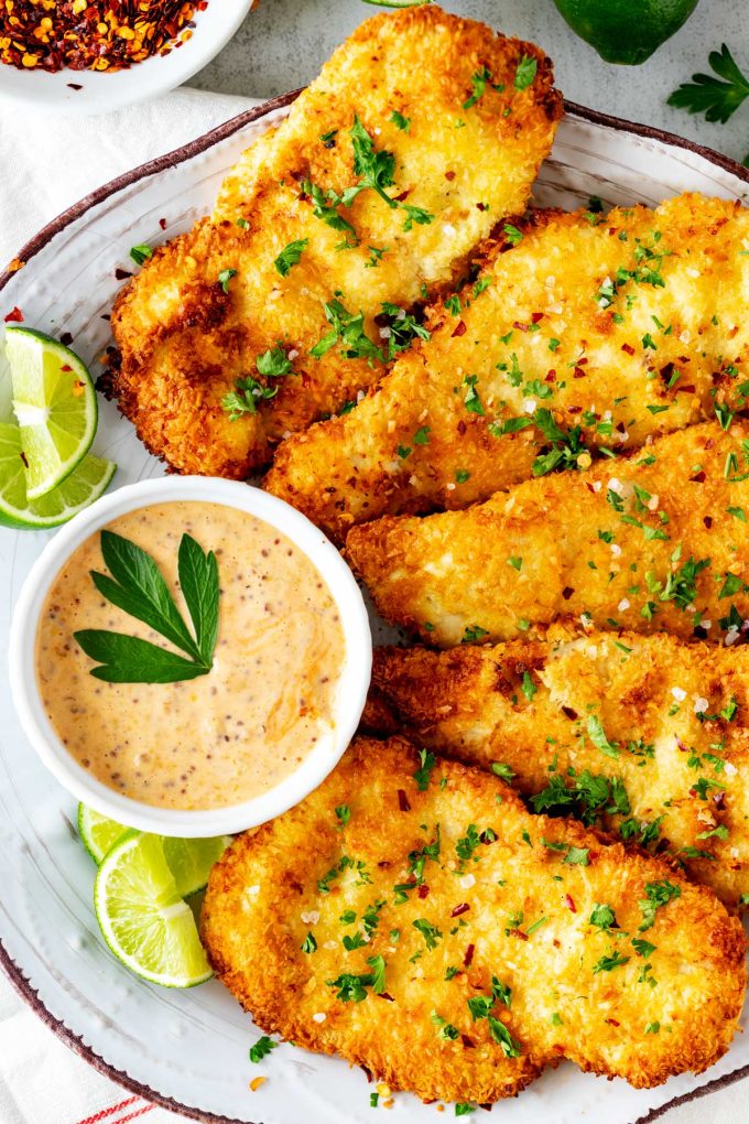 Close up overhead photo of a plate of keto coconut chicken with a small dish of dipping sauce.